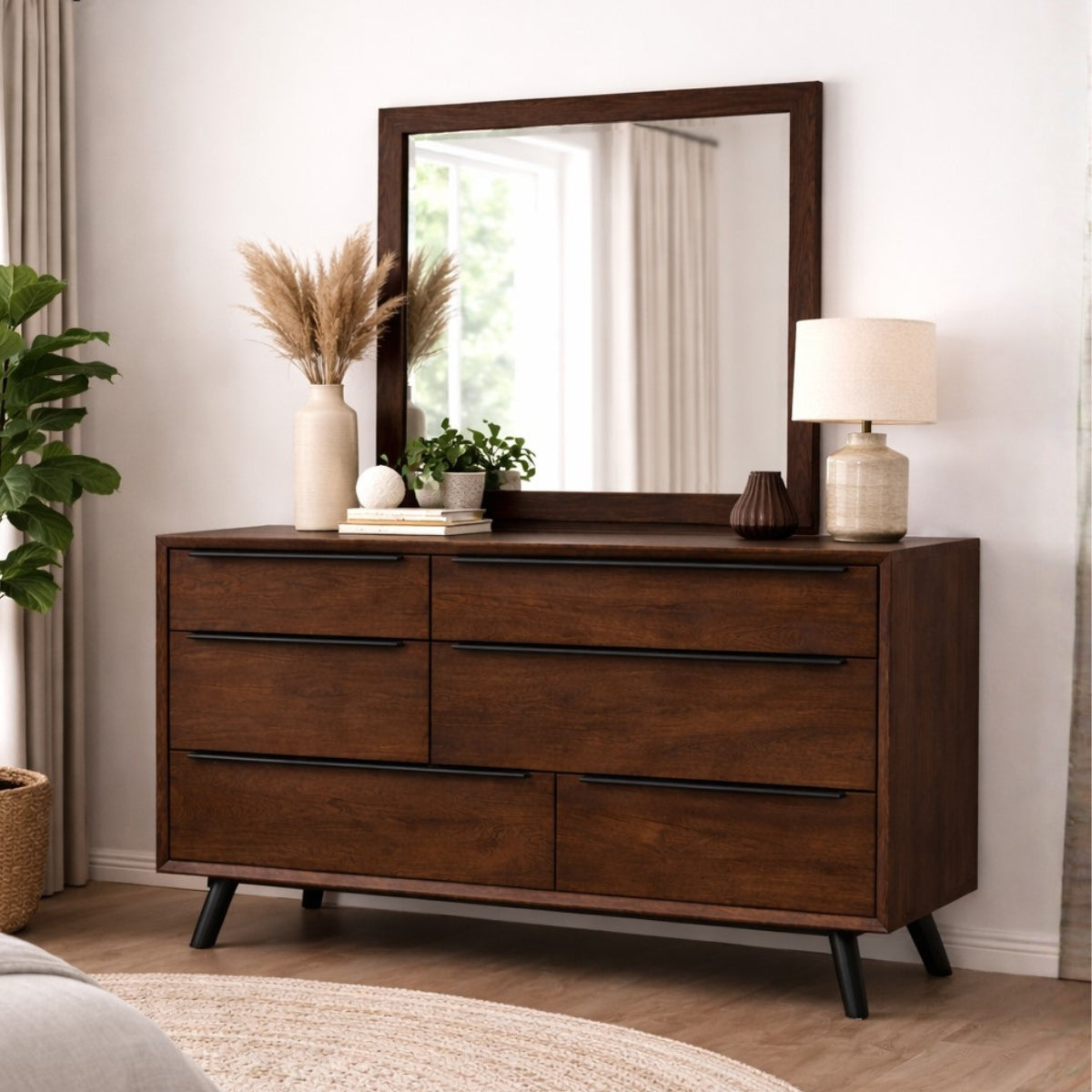 Mid century modern chest of drawers with mirror, lamp, and decorative items in a room setting.