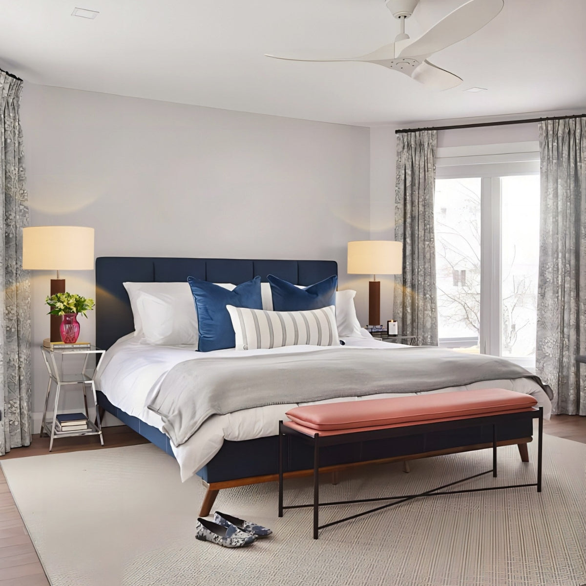 Modern bedroom with a large bed, bench, and lamps.
