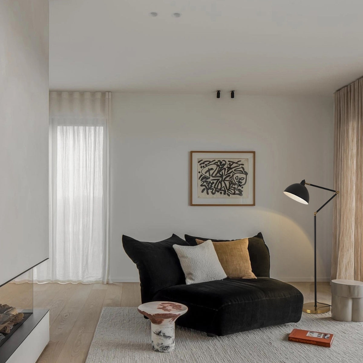 Modern living room with a black sofa, decorative pillows, and a floor lamp.