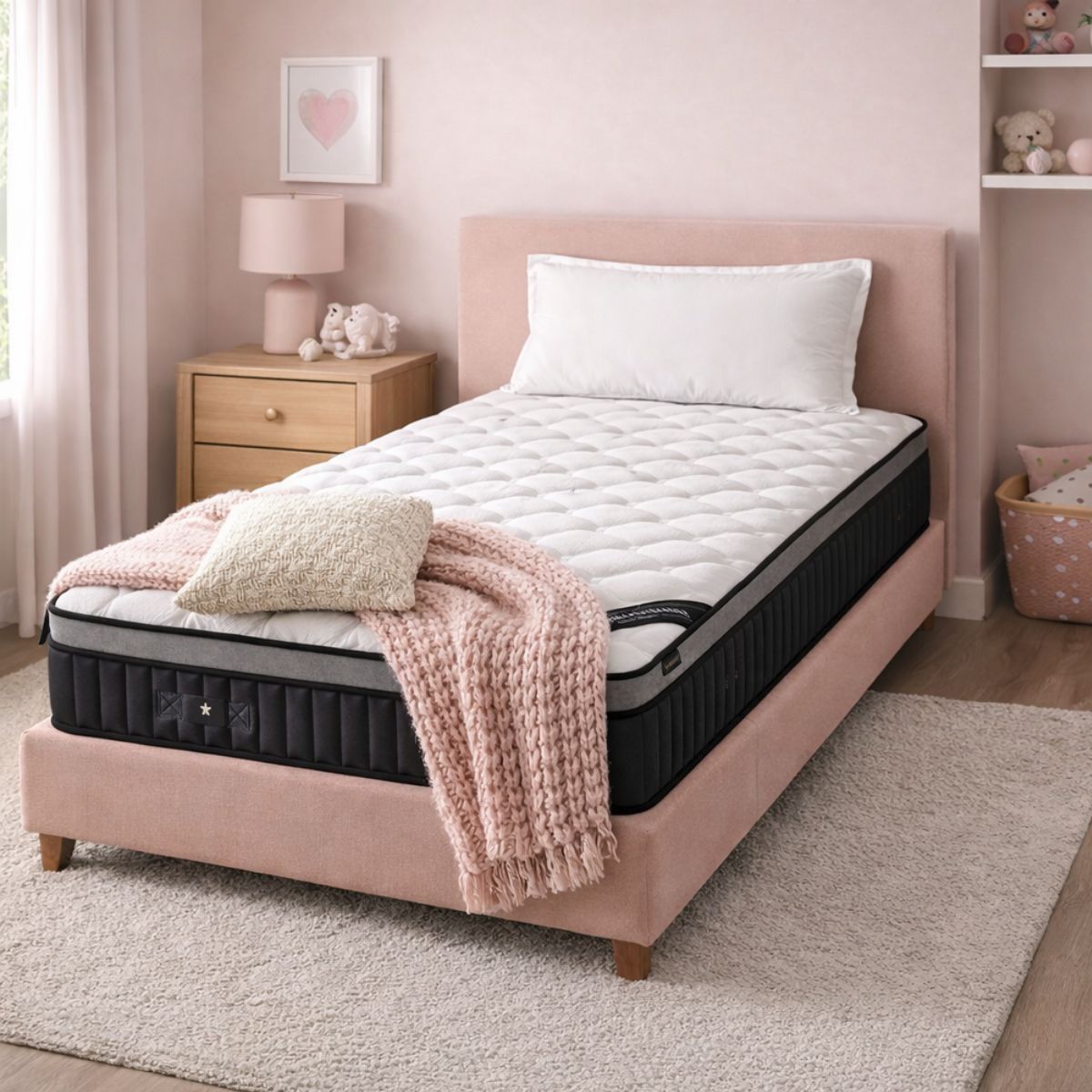 Pink bed with white mattress and pink blanket in a bedroom setting