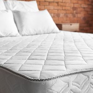 a 4ft mattress against brick wall