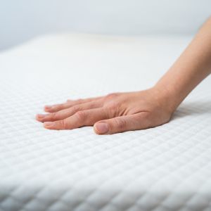 a lady touching a firm mattress