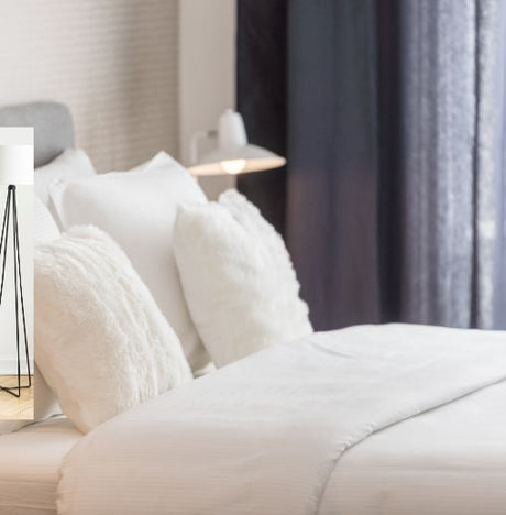 Bed with white linen and cushions.