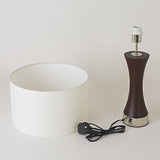 Lamp with white shade and brown base on a light gray background