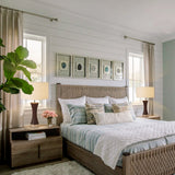 Neatly arranged bedroom with a bed, nightstands, lamps, and decorative elements.