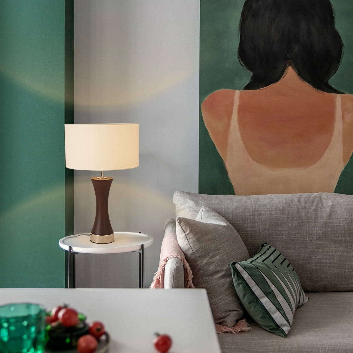 Living room with a lamp on a side table and a sofa with decorative pillows.