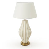 Decorative table lamp with ribbed design and white shade on a white background