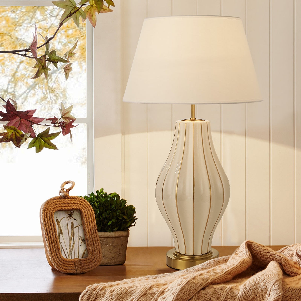 Decorative lamp on a table with a window and plant in the background