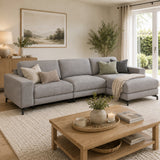 Living room with the Gates grey sectional sofa, wooden coffee table, and decorative elements.