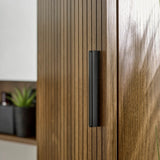 Close-up of the Hampshire wooden cabinet with a black handle, blurred background.