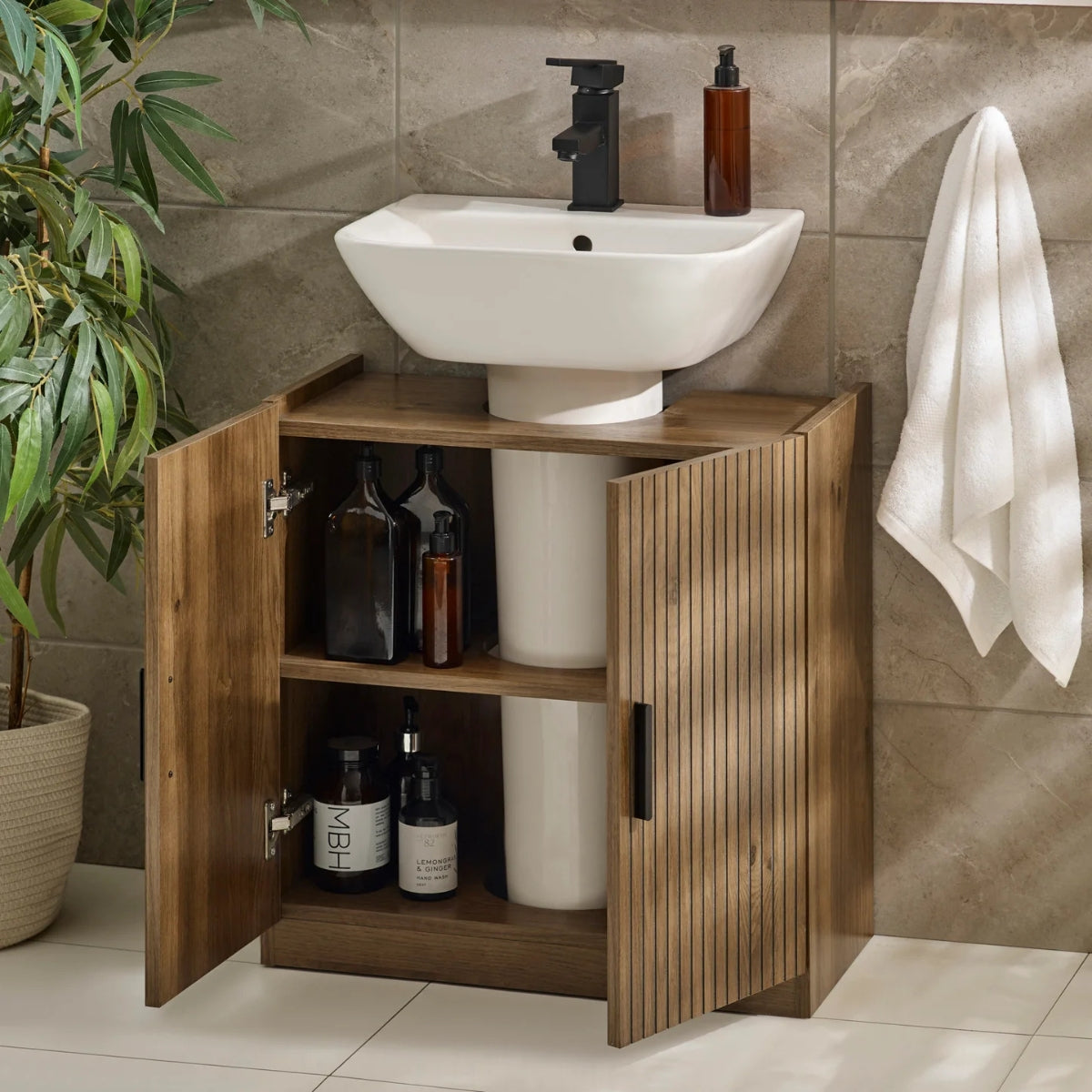 Hampshire bathroom vanity with open cabinet, sink, and toiletries against a tiled wall.