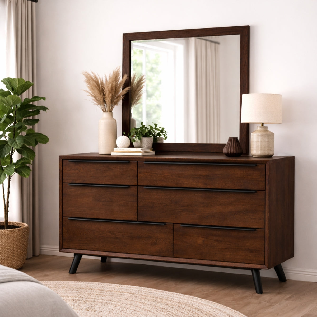 Wooden mid century modern chest of drawers with mirror, lamp, and decor in a room setting