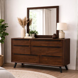 Mid century modern chest of drawers with mirror, lamp, and decorative items in a room setting.
