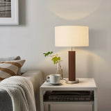 Modern living room with a lamp on a side table, sofa, and framed picture.