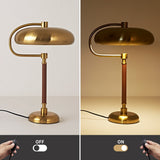 Gold desk lamp with switch on a white background