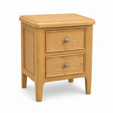 Maldon light oak wood two-drawer nightstand with a rounded top and silver round knobs, shown on a white background.