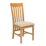 Maldon wooden dining chair with a slatted backrest and a light beige upholstered seat cushion, shown on a plain white background.