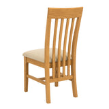 Maldon wooden dining chair with a slatted backrest and a light beige upholstered seat cushion, shown from a three-quarter angle on a plain white background.