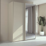 Trixie beige wardrobe with a mirror in a room with curtains and a plant.