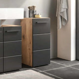 Bathroom vanity with black cabinets and wooden accents, featuring a sink and towel.