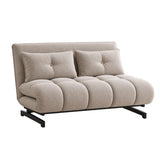 A modern compact futon sofa in a light beige textured fabric, featuring a low back, two matching tufted back cushions, a segmented bubble seat, and a black metal frame.