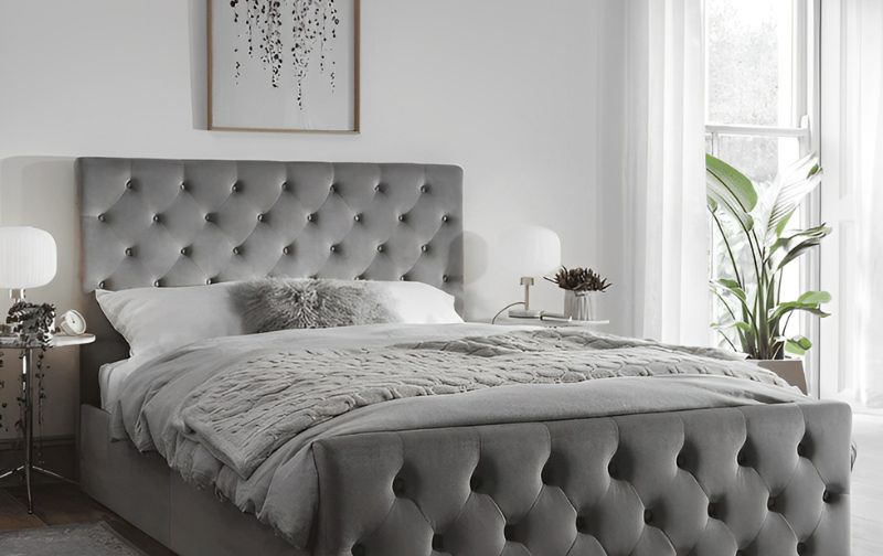 Silver velvet tufted bed frame with silver throw.