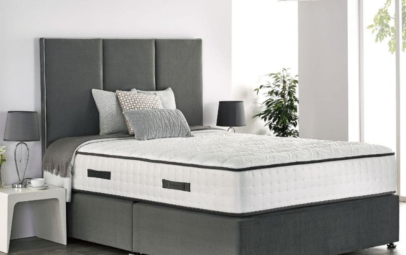 Mattress on grey bed base and headboard.