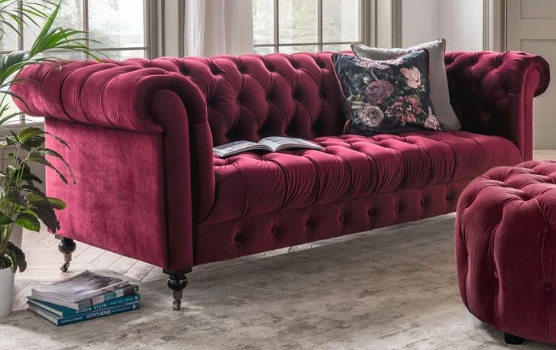 Burgundy chesterfield velvet sofa with matching ottoman.