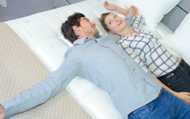 Couple lying on mattress.