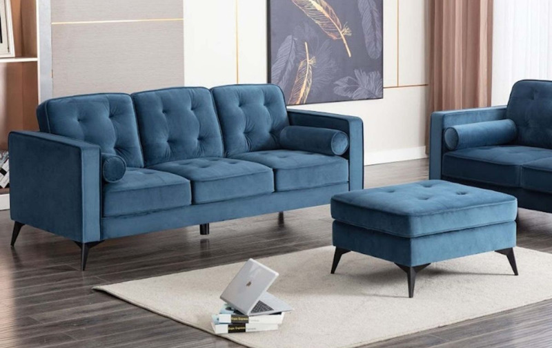 Contemporary velvet teal three piece sofa with matching ottoman and cream rug.