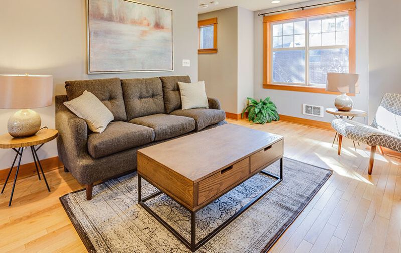 Small brown sofa with wooden coffee table.