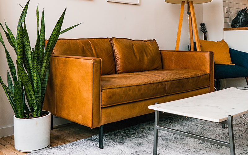 Tan leather minimalist sofa with black steel legs.