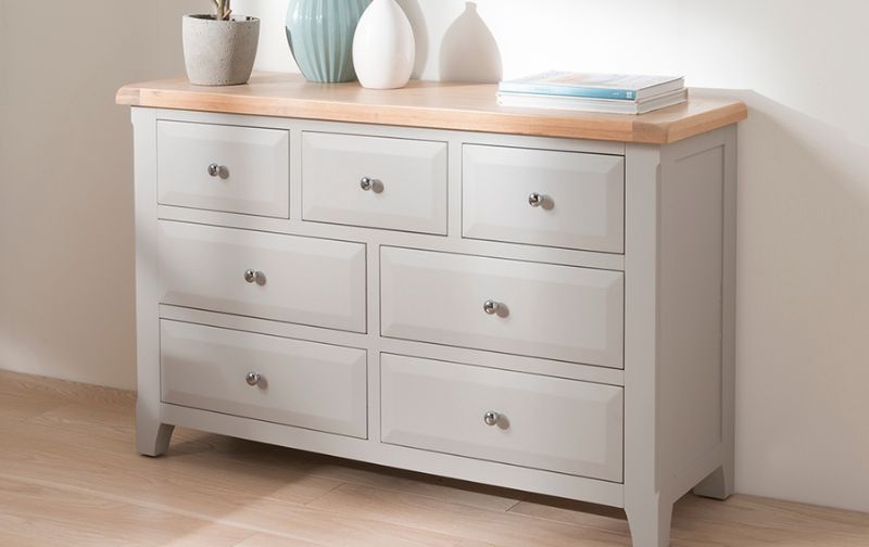 Traditional-ivory-chest-of-drawers-with-silver-knobs-and-wooden-surface