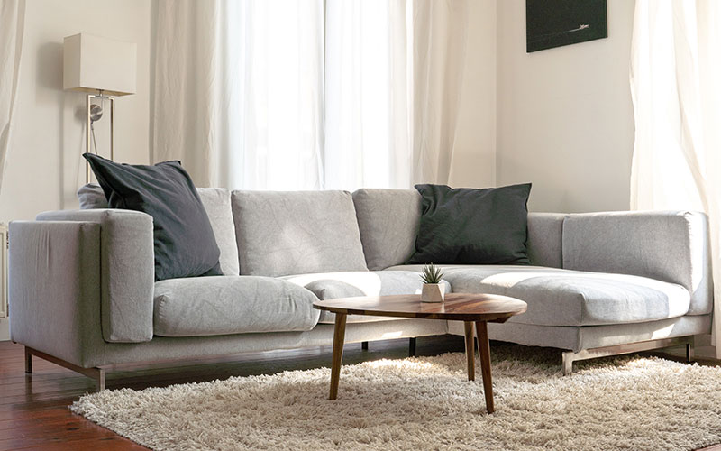 Grey corner sofa with large scatter cushions.
