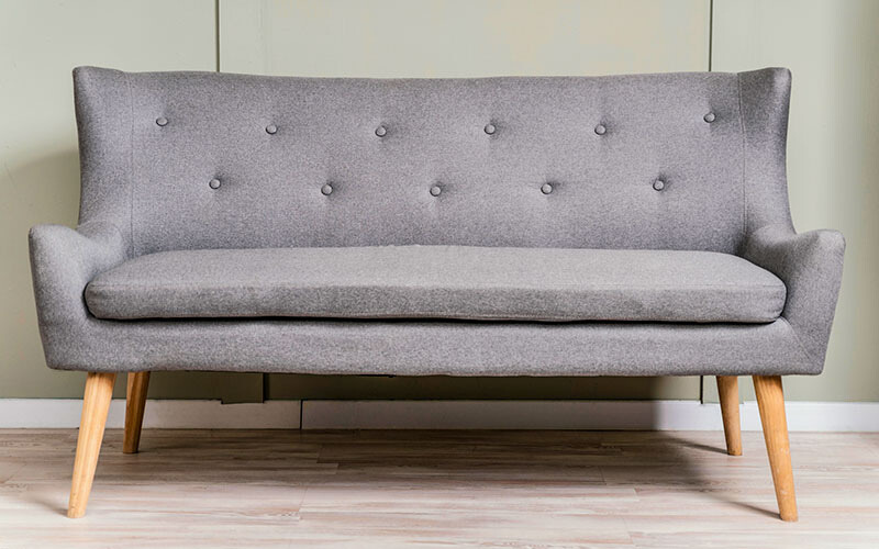 Chesterfield grey loveseat with wooden legs.
