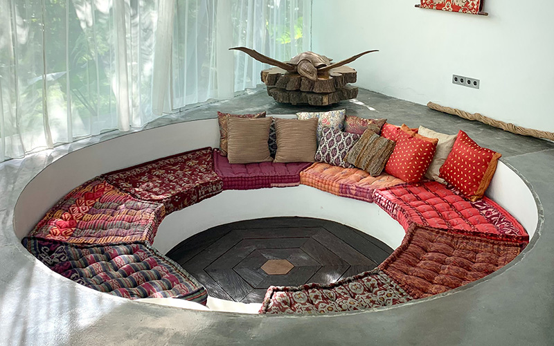 Circular fire pit sofa in large living room.
