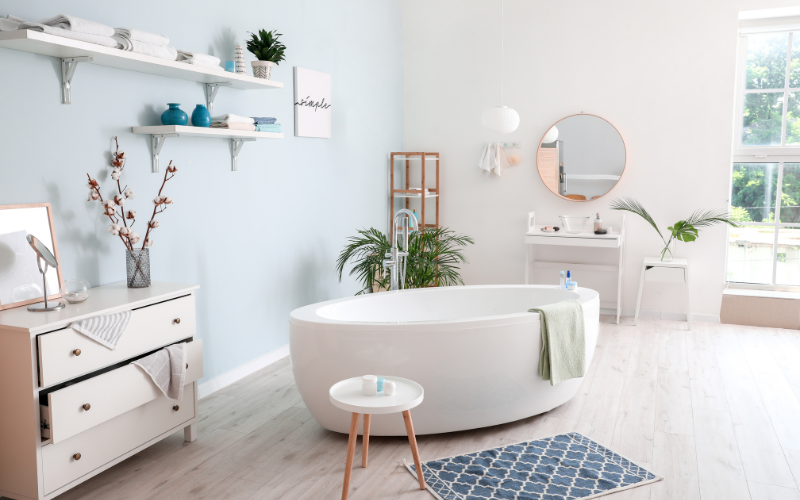 a coastal style bathroom with a tub and a mirror