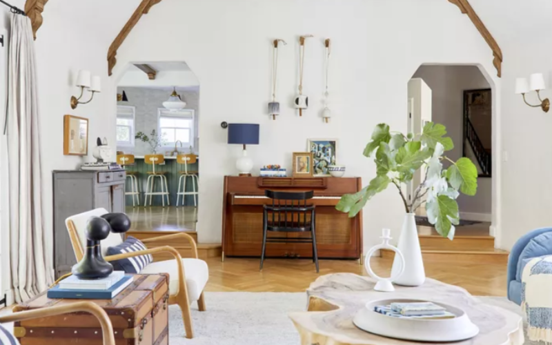 a living room with a piano and a white chair