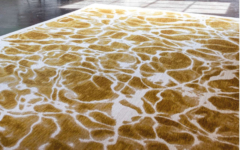 A rug in gold and cream on a floor