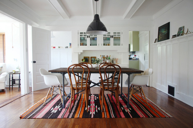 a dining table with chairs on a kilim rug in a room