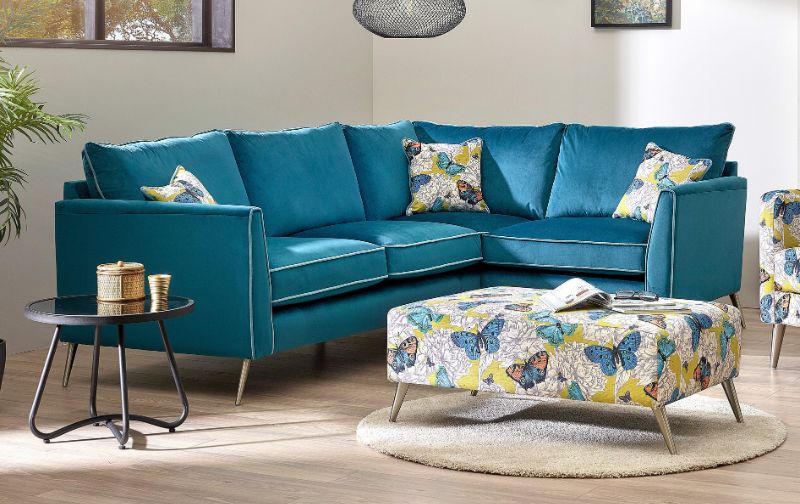 Teal corner sofa with floral cushions and ottoman
