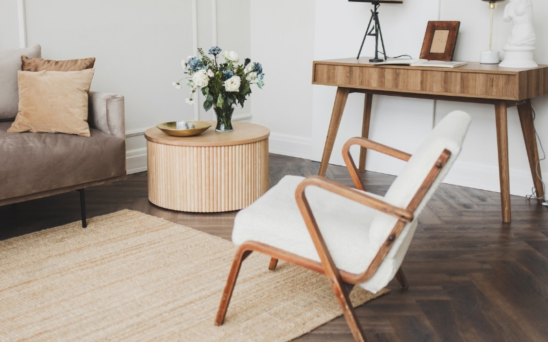 a chair and a table resting on a beige rug with flowers