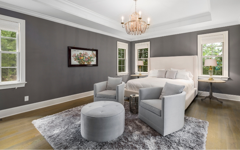 a bedroom with a bed and chairs and grey rug colour