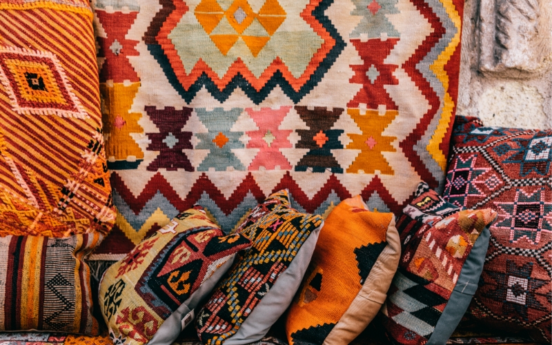 a group of pillows with a kilim pattern rug