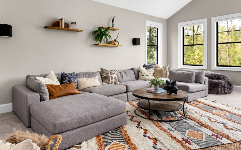 a living room with a large couch and a coffee table on a large rug