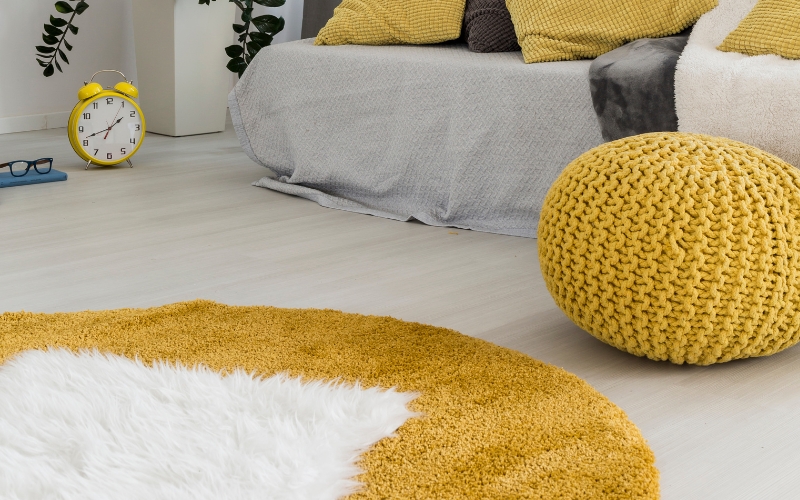 a yellow and white rug on a white floor