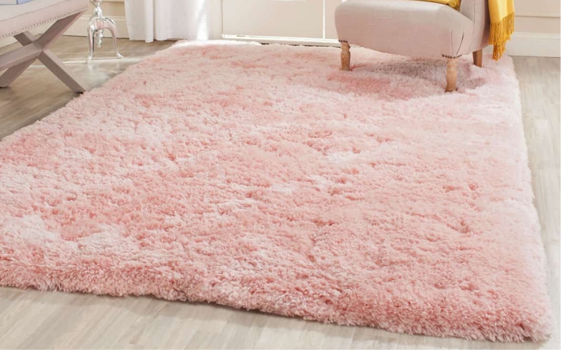 a pink rug on bedroom floor