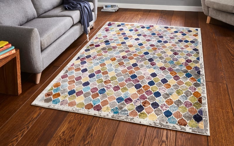 a rectangular rug on a wood floor