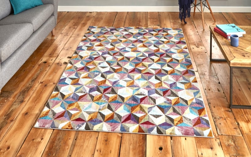 a rectangular area rug on a wood floor