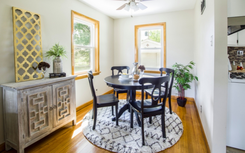 round rug on floor with dining table and chairs